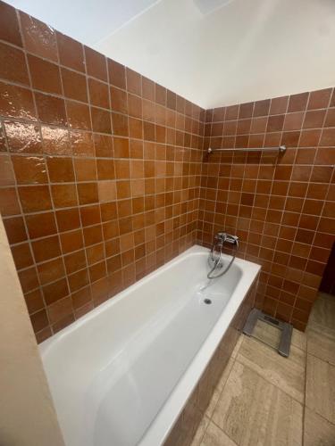 La salle de bains est pourvue d'une baignoire et de carrelage brun. dans l'établissement Villa golfe st tropez area & swimming pool, à Grimaud