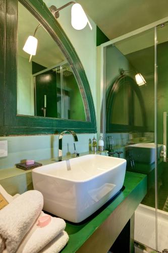 La salle de bains est pourvue d'un grand lavabo blanc et d'un miroir. dans l'établissement Clos BB, à Saint-Cyr-sur-Mer