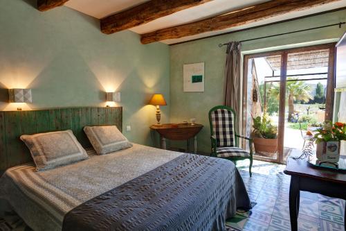 Schlafzimmer mit einem Bett, einem Tisch und einem Fenster in der Unterkunft Clos BB in Saint-Cyr-sur-Mer