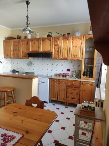 a kitchen with wooden cabinets and a table in it at Casa Cambria in Bagnoli Irpino