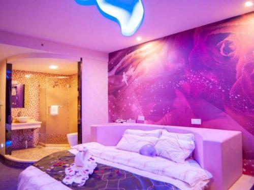 a bedroom with a white bed and a purple wall at Impression Li River Hotel (Guilin North Railway Station Branch) in Guilin