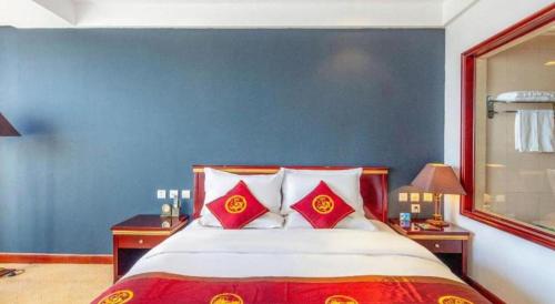 a bedroom with a large bed with red and white pillows at Datong Tiangui International Hotel in Datong
