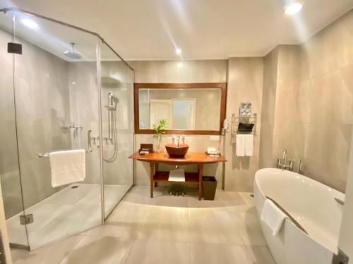 a bathroom with a shower and a tub and a sink at Sokha Phnom Penh Residence in Phnom Penh