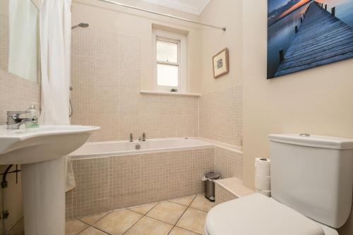 Un baño con bañera, inodoro y lavabo. en The Cavendish, en Eastbourne