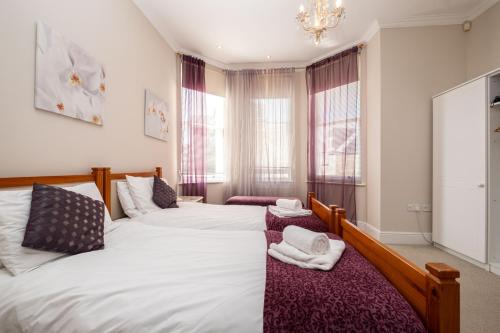 Un dormitorio con dos camas y una lámpara de araña. en The Cavendish, en Eastbourne