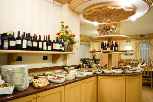 um buffet com muita comida e garrafas de vinho em Hotel Abete Bianco em Andalo