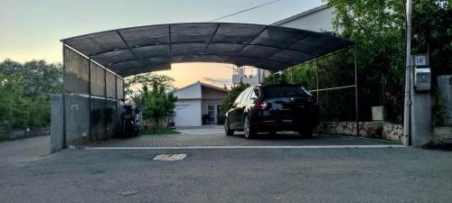a car parked under a garage with a carport at Apartment Bokanjac Free Covered Parking & Quiet Neighborhood in Zadar