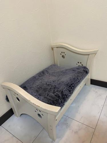 a small white bed in a corner of a room at 京都観光に最適 ペットok 名神東インターから1分 3LDK無料駐車場付 京都駅から1駅 山科駅周辺 蹴上インクラインまで10分 in Kyoto