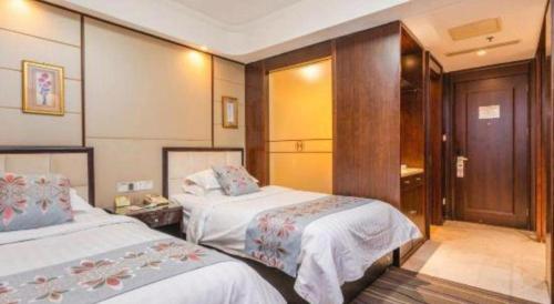 a hotel room with two beds and a bathroom at Qingdao Minlian Kaixuan Hotel in Qingdao