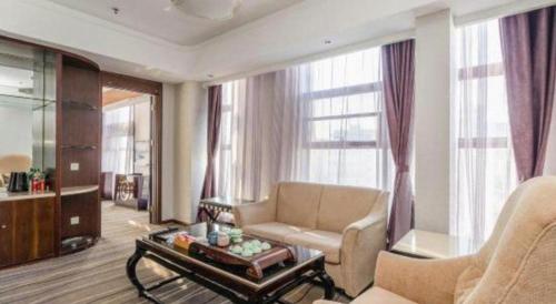 a living room with a couch and a table at Qingdao Minlian Kaixuan Hotel in Qingdao