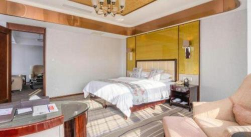a bedroom with a bed and a tub in a room at Qingdao Minlian Kaixuan Hotel in Qingdao