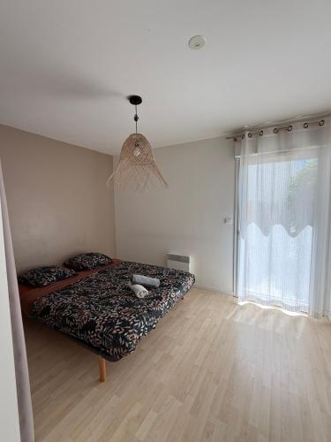 une chambre avec un lit et une grande fenêtre dans l'établissement Joli T2 Lumineux proche mer !, à Angoulins-sur-Mer