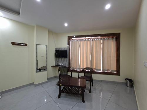 a room with a table and chairs and a window at Hotel Velga in Kurukshetra