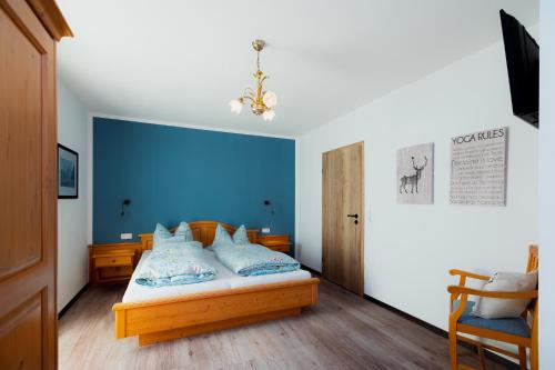 a bedroom with a bed with a blue wall at Ferienwohnung Mankei in Schönau am Königssee