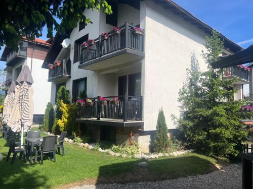 a building with a table and chairs in the yard at Guest House Raffe in Dobrinishte