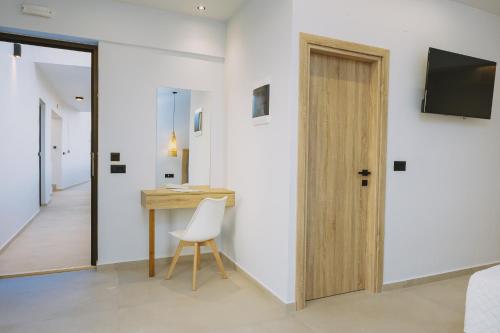 a room with a desk and a chair and a door at Aegean View Hotel in Sfakaki