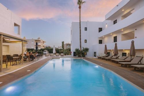 a large swimming pool in a hotel with people sitting around at Aegean View Hotel in Sfakaki