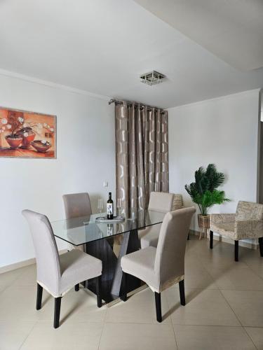 a dining room with a glass table and chairs at Diwani Luxury Villas in Lixouri