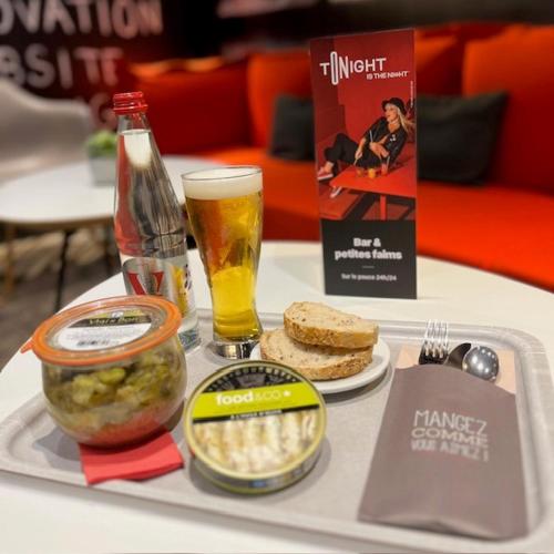 a tray of food and a glass of beer on a table at ibis Alençon in Alençon