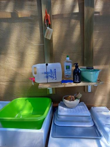 a kitchen counter with plates and bowls on a shelf at TENTES sur une aire privée en pleine nature in Massillargues-Attuech