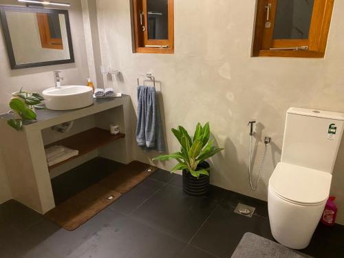 a bathroom with a sink and a toilet at New Palms Villa Induruwa Homestay in Induruwa