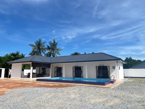 a house with a swimming pool in front of it at Untung5tay in Gua Sai