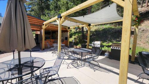 a patio with tables and chairs and an umbrella at Allen Gulch Motel in Hill City