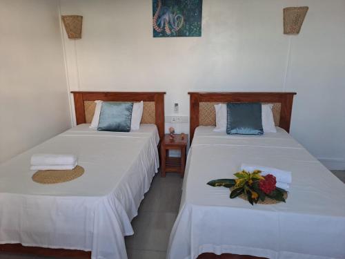 two beds sitting next to each other in a room at La Residence Emmaüs in Rodrigues Island