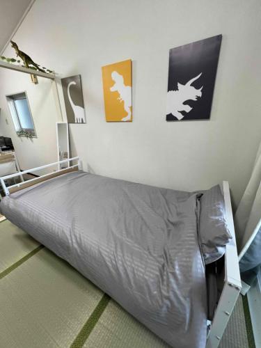 a bedroom with a bed and some pictures on the wall at 福井駅東口から徒歩10分駐車2台可スーパーまで2分民泊 eclat エクラ 城東 in Fukui