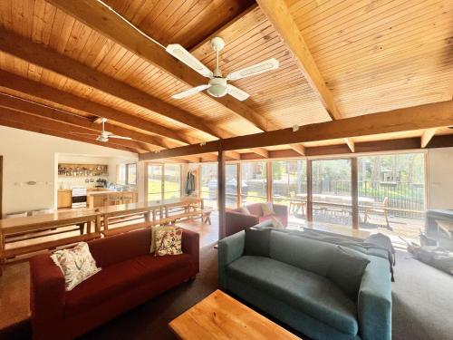 a living room with couches and a ceiling fan at Albaski Lodge Room 1 in Mount Buller