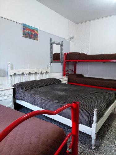 Un dormitorio con dos camas y un espejo. en Hostal La Pachamama, en Salta