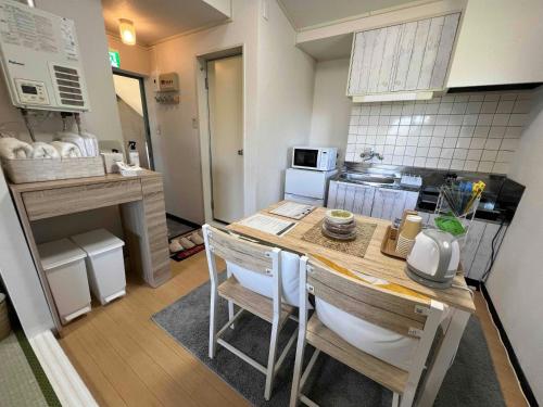 a small kitchen with a table and chairs at 福井駅東口から徒歩10分駐車2台可スーパーまで2分民泊 eclat エクラ 城東 in Fukui