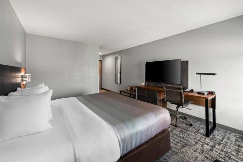 a hotel room with a bed and a desk with a computer at Quality Inn & Suites Manhattan in Manhattan
