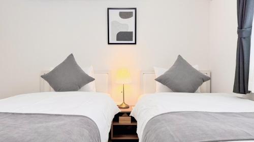 two beds sitting next to each other in a bedroom at Villa Konatsu -小夏- in Nago