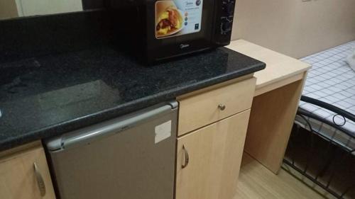 a kitchen with a microwave on top of a counter at Budget Condotel in Manila