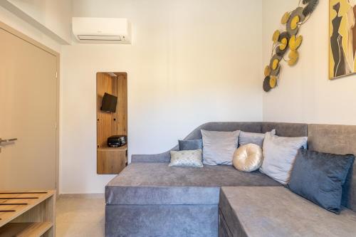 a living room with a gray couch with pillows at Artion Suites Nikiti in Nikiti