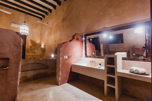 a bathroom with two sinks and a large mirror at Hacienda Sacnicte in Izamal