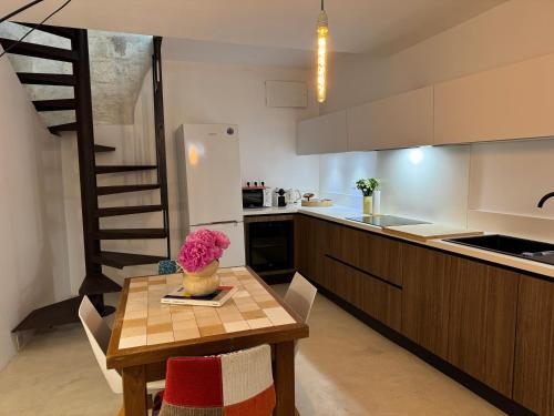 une cuisine avec une table en bois et une cuisine avec un escalier dans l'établissement Maison Cosy avec rooftop et BBQ - Roquette, à Arles