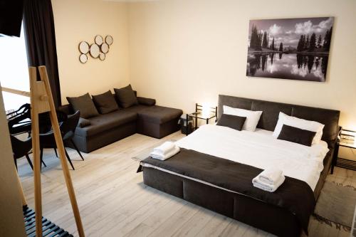 a bedroom with a bed and a couch at SergJuli Villa in Plavecký Štvrtok