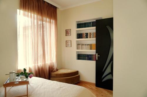 a bedroom with a bed and a chair and a window at Luna in Kutaisi