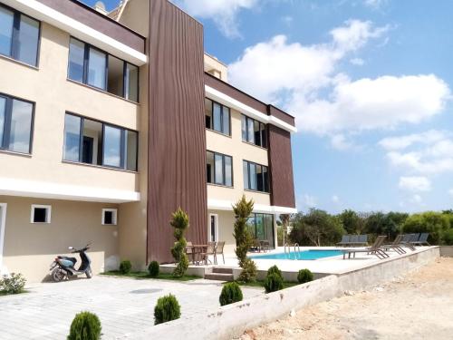un edificio con una moto parcheggiata accanto a una piscina di METTE Otel a Silifke