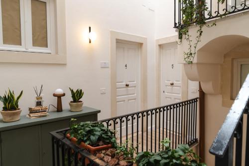 a balcony with plants and a stair railing at xenia apartments & suite in Siracusa