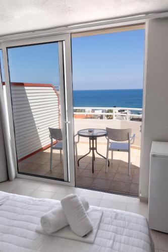 a bedroom with a bed and a view of the ocean at Kumba in Nea Chora in Chania Town