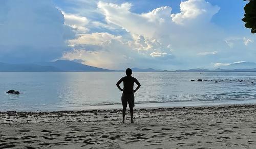 a man standing on the beach looking at the water at RAINFOREST Nest Self-Service Home in Subic Bay - Monkeys, Bats, Roofdeck! in Subic Bay Intl