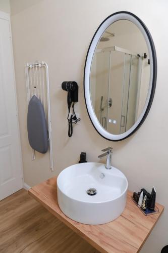a bathroom with a white sink and a mirror at xenia apartments & suite in Siracusa