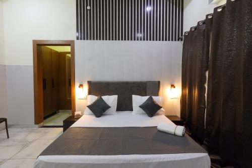 a bedroom with a large bed with black and white pillows at Hotel Sapphire in Narwāna