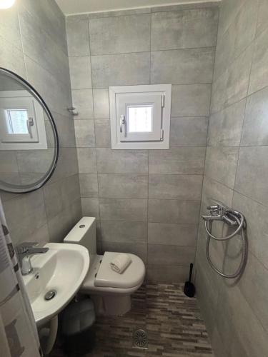 a bathroom with a sink and a toilet and a mirror at Michalis Home in Nea Kalikratia