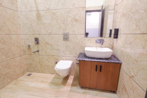a bathroom with a toilet and a sink and a mirror at Hotel Sapphire in Narwāna