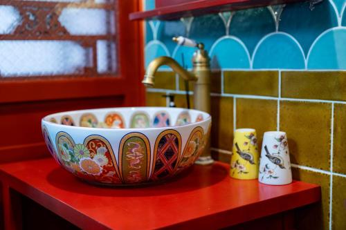 a bowl sitting on a red counter next to a sink at Beijing city center - Courtyard house hotel located in an ancient Hutong, near the Forbidden City,experience the lifestyle of old Beijing in the exquisite Chinese-style courtyard in Beijing