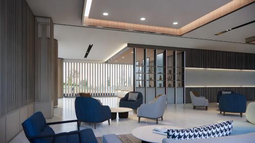 a waiting room with blue chairs and a table at Fairfield by Marriott Bali Kuta Ngurah Rai in Kuta